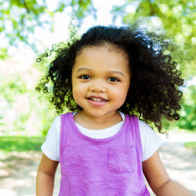 toddler girl smiling wearing purple shirt