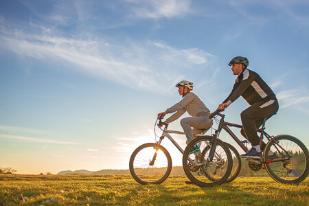 Man and woman cycling in nature at sunrise