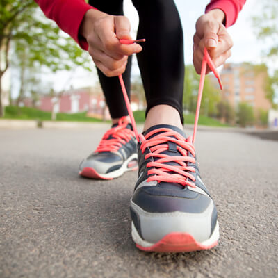 woman tying athletic shoe