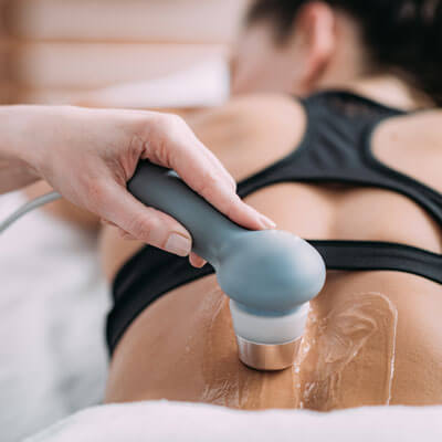 Woman receiving ultrasound therapy on lower back