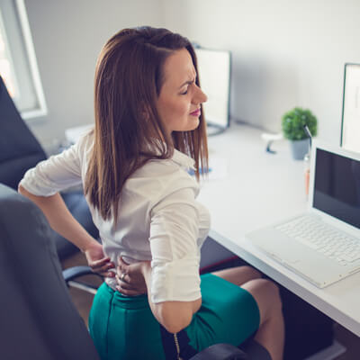 Woman at desk with low back pain