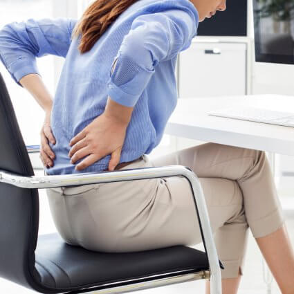 woman sitting at a desk with lower back pain