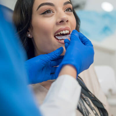 woman being fitted with aligners
