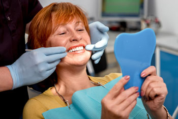 Woman admiring new smile in mirror