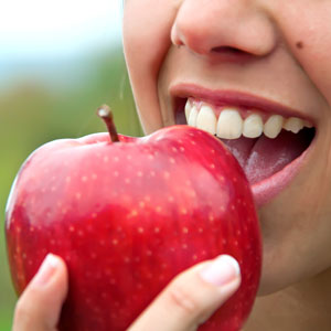 Woman about to bite into an apple