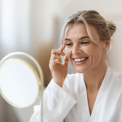 smiling woman looking into a mirror