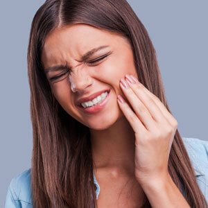Woman grimacing with jaw pain