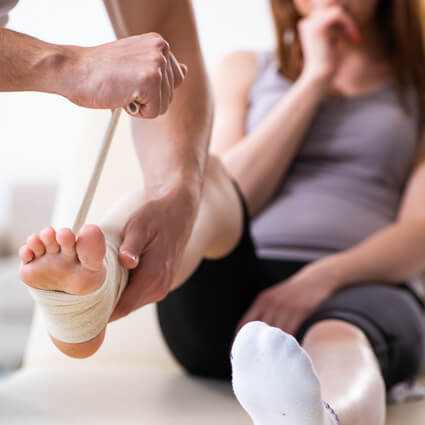 Woman having foot bandaged