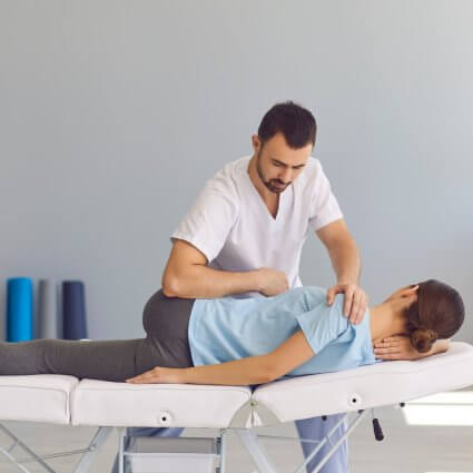 Chiropractor performing a hip adjustment on a patient