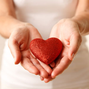 Woman holding a red heart in her hands