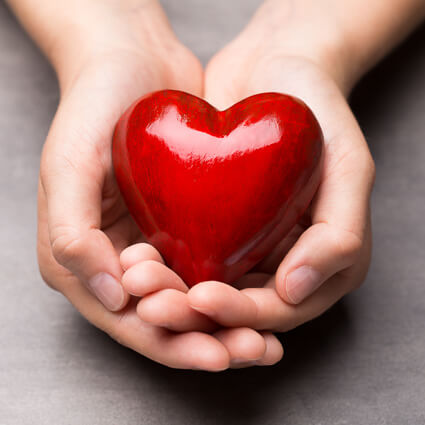 woman holding red heart shape in hands