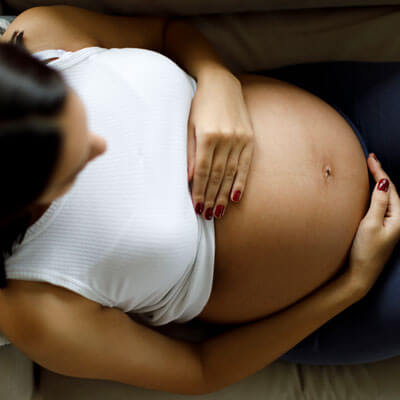 woman holding pregnant belly top view