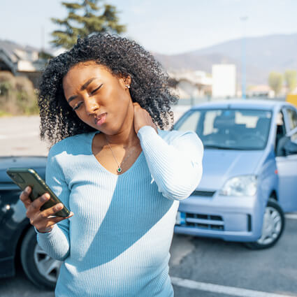 person looking at phone after an auto accident