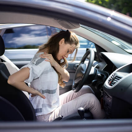 Woman in car with neck and back pain