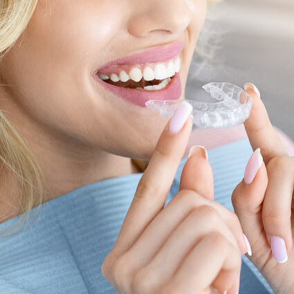 Woman holding clear aligner