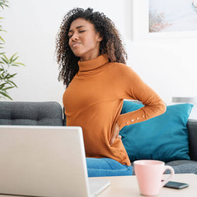 woman in orange sweater at home-back pain