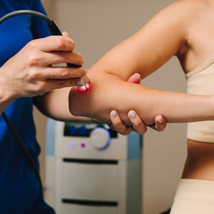 Woman with laser therapy on elbow