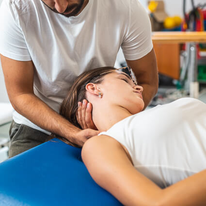 Physiotherapist gently assessing a patient's neck movement
