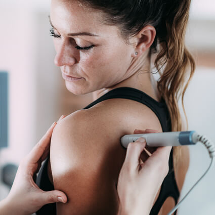 Woman looks over her shoulder receiving laser therapy
