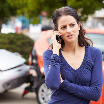 person on phone after auto accident