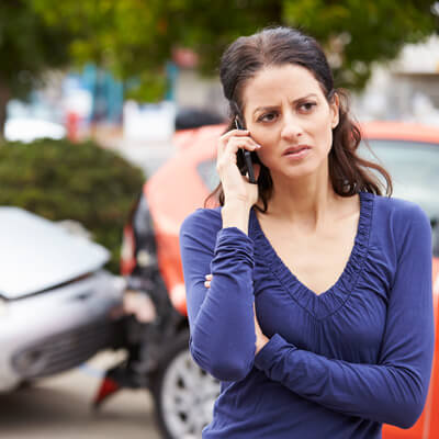 woman making a phone call after car wreck