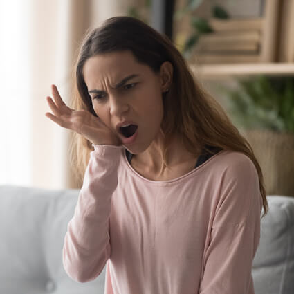 Woman on couch experiencing dental pain
