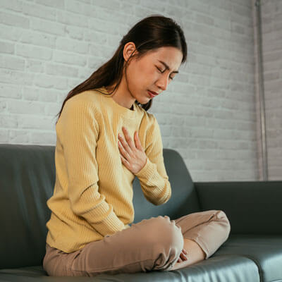 woman on couch with heartburn