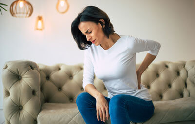 woman on fancy couch with back pain