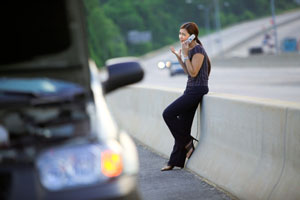 woman on the phone next to wrecked car