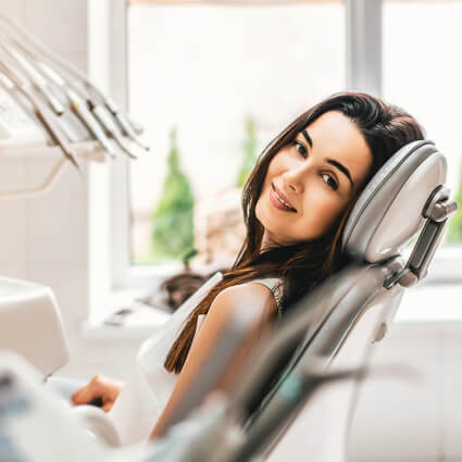 smiling woman sitting in dentists chair