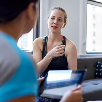 woman pointing at shoulder during a consultation