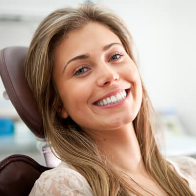 woman showing smile on dental chair