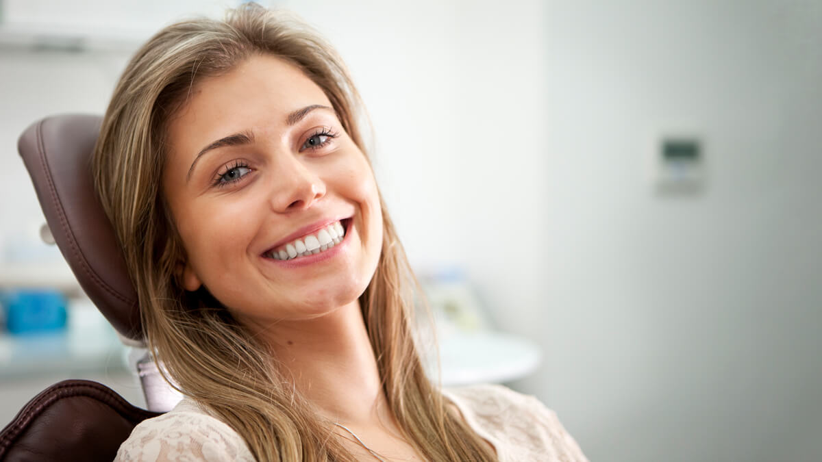 smiling person in dentists chair