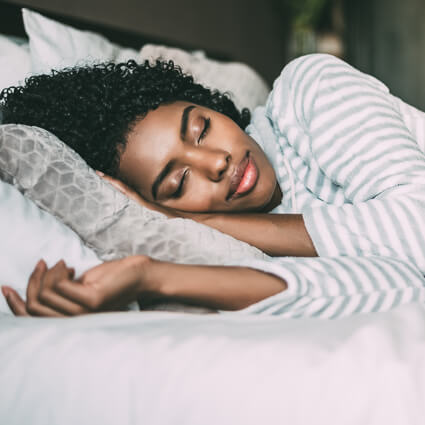 woman sleeping happily in bed