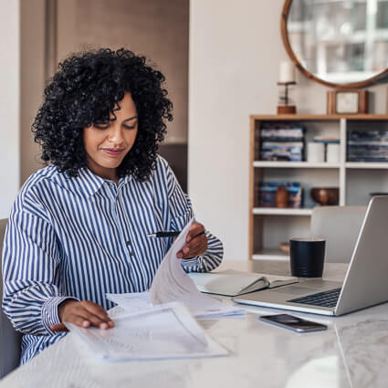 woman at computer looking at papers