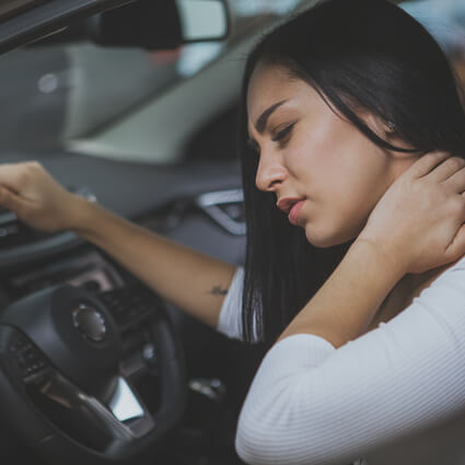 Woman sitting in car with neck pain