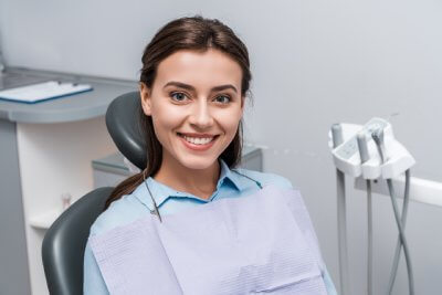 Smiling female patient sitting on dental chair