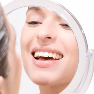Woman looking at teeth in mirror