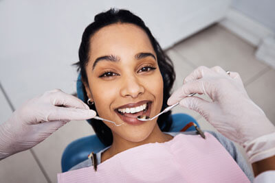 Woman smiling with dental instruments
