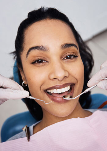 Woman smiling while getting teeth cleaned