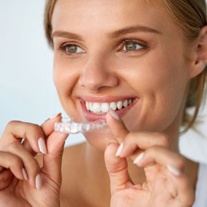 woman smiling with an invisalign aligner