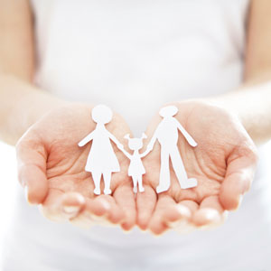 A woman holding a paper cut out of a family.