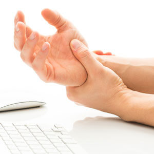 Person holding wrist at desk