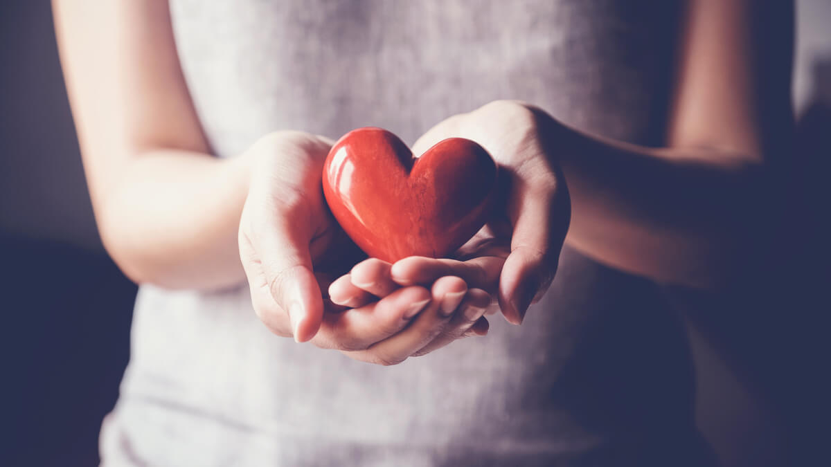 hands holding glass heart