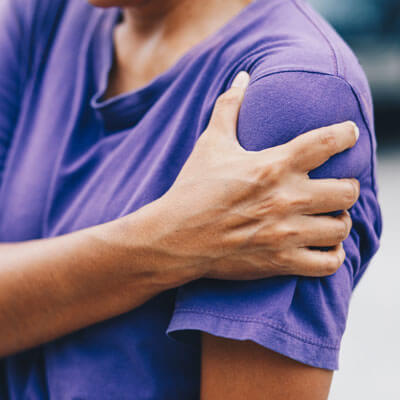Adult holding shoulder in pain