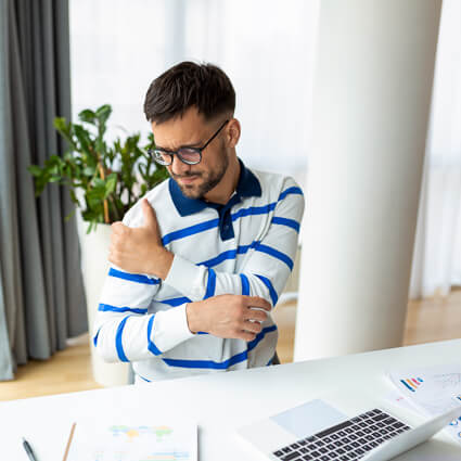 Man with shoulder pain at office desk