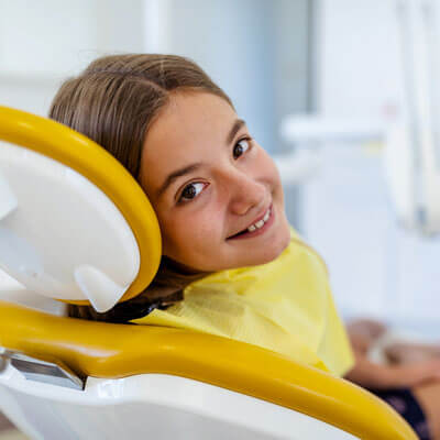 Girl looking back over dental chair