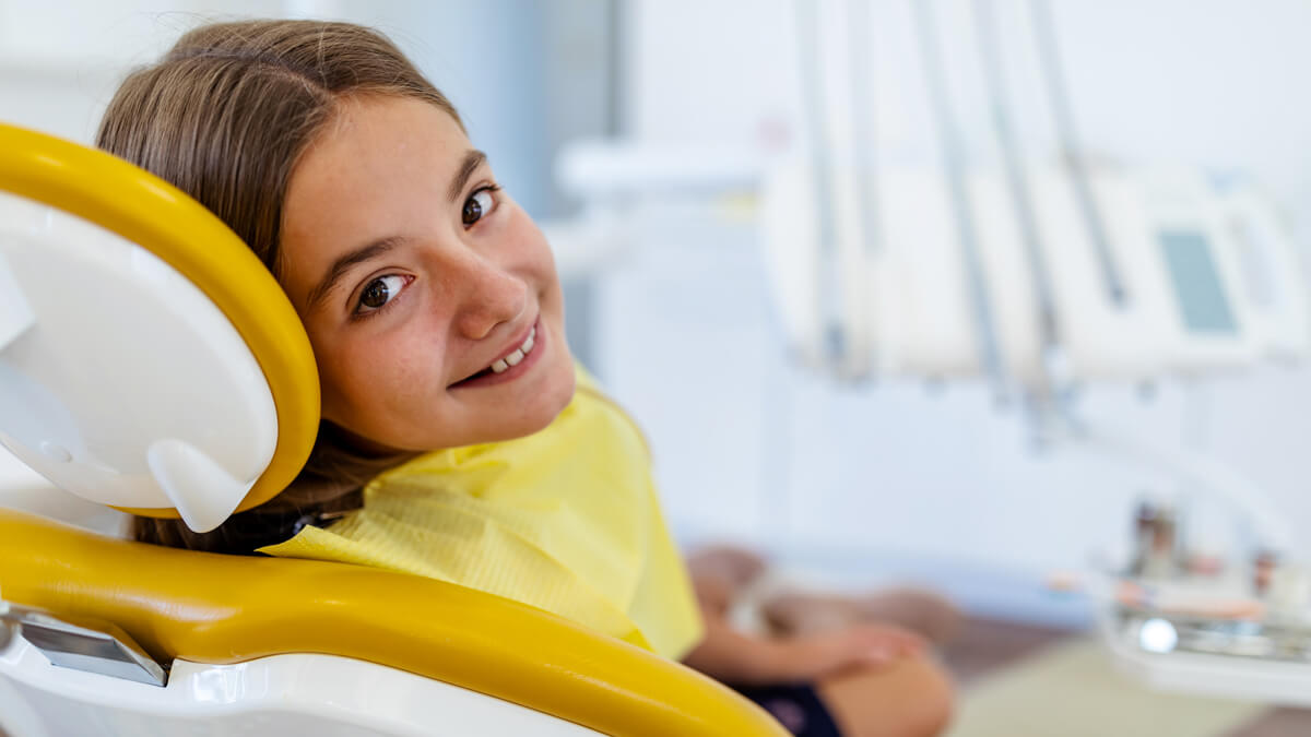 young girl in yellow dental chair