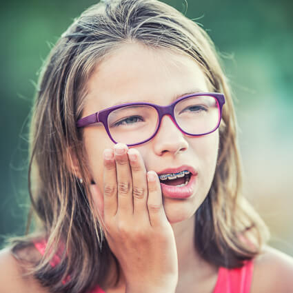 young girl with braces with jaw pain