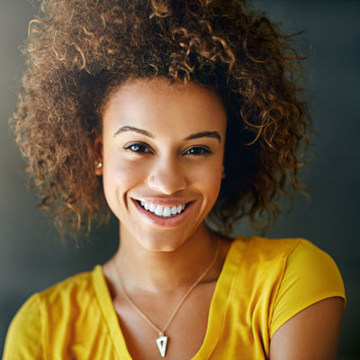 Woman with beautiful, white smile wearing yellow shirt